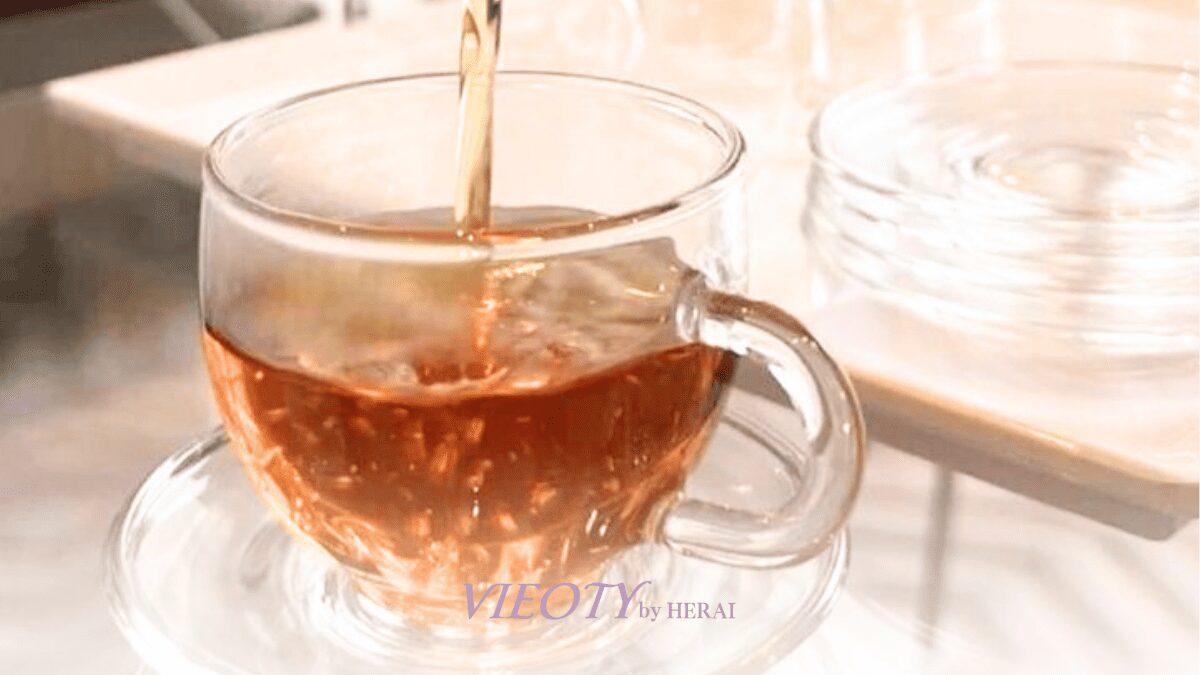 窓からの柔らかな光の中で、エリクティーを飲みながら静かに目を閉じている女性が淹れているイメージ