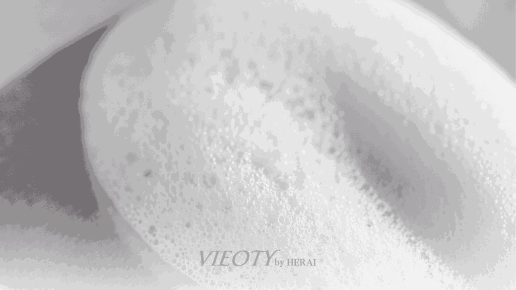 輝くハーモニーウォッシュのシルクのような滑らかな泡が、ドレープを描き、髪と肌のイメージに優しく溶け込んでいるアート的な写真