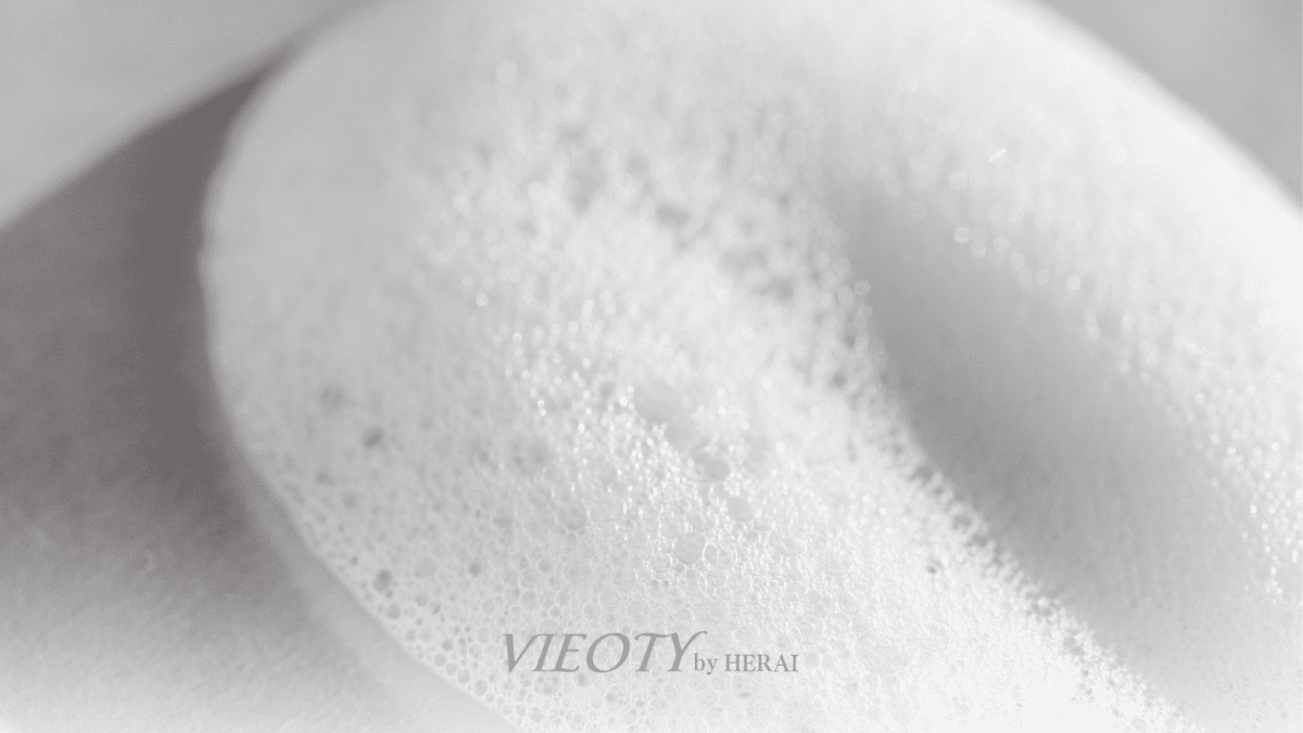 輝くハーモニーウォッシュのシルクのような滑らかな泡が、ドレープを描き、髪と肌のイメージに優しく溶け込んでいるアート的な写真