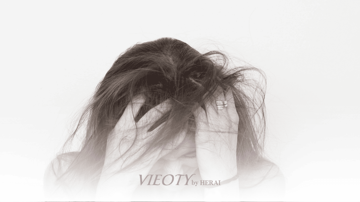 くせ毛の女性が頭を抱えている様子