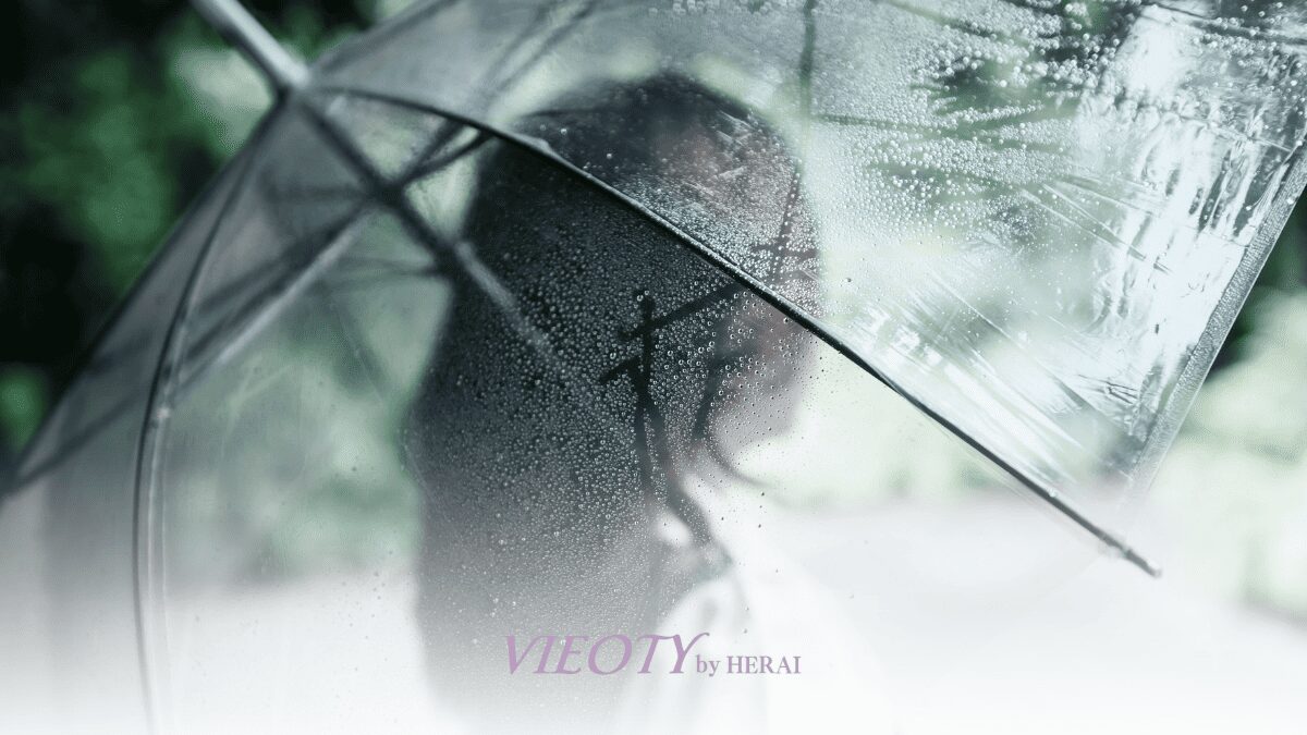 雨の日、髪の広がりを抑え、傘をさしている女性