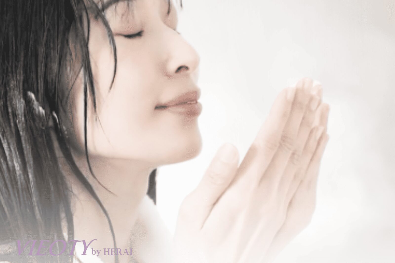 VIEOTYのクリームを両手で温め、その豊かな香りを深く吸い込む女性の手元。