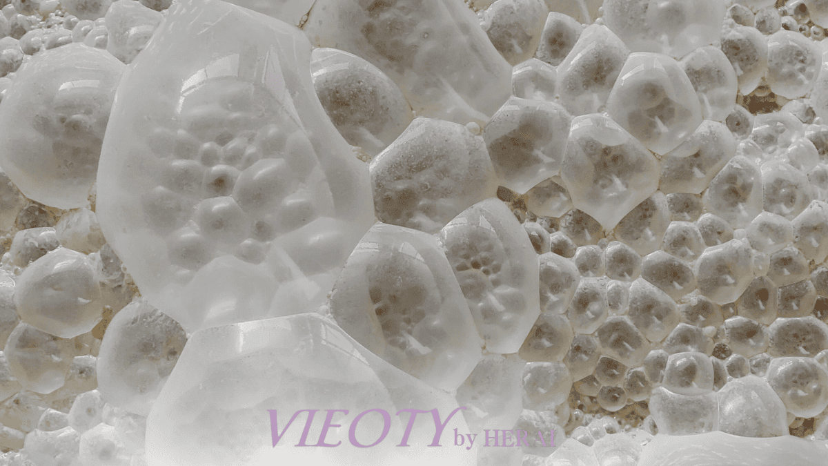 発酵コスメの力を象徴する一滴のエッセンスが水面に落ちる瞬間。米や酵母の恵みが凝縮され、肌の角質層へ浸透していく科学的なイメージ。