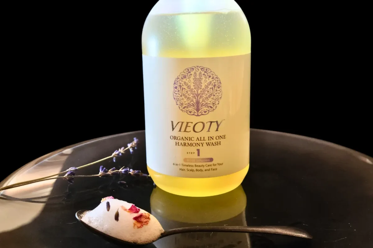 VIEOTYハーモニーウォッシュ。黒いプレートに盛り付けられた泡とダマスクローズ、ラベンダーの花、そしてボトル。