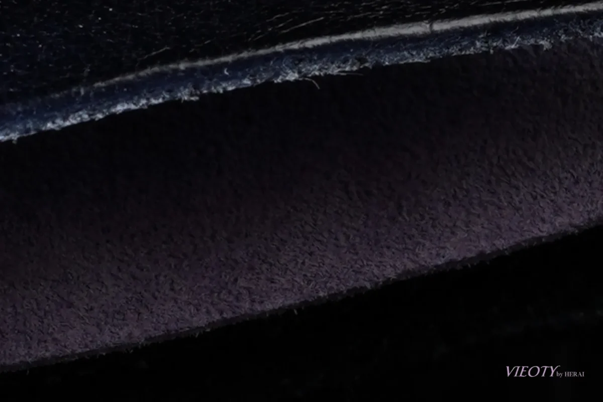 ブラックのレザーのフラップを開けた瞬間にだけ覗く、東京産ピッグレザーの紫の裏地